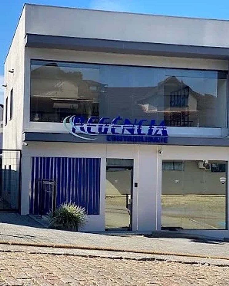 Fachada do escritório da Regência Contabilidade em Joinville, com o nome da empresa na janela.